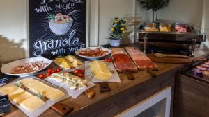 a buffet with different types of cheese and other foods at Eola Leisure Rooms in Stara Baška