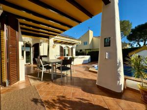 a patio with a table and chairs on a house at Ibiza style villa first line to golf! in Villamartin +39 photos