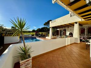 a house with a swimming pool and a patio at Ibiza style villa first line to golf! in Villamartin