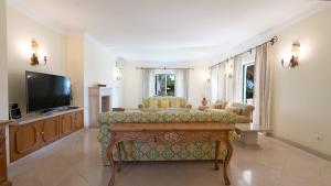 a living room with a couch and a tv at Casa Atlantico in Quinta do Lago