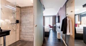 a bathroom with a walk in shower and a sink at PLAZA Premium Heidelberg in Heidelberg