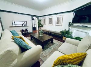 a living room with white couches and a coffee table at Charming home in Central Dubbo in Dubbo