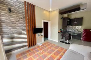 a living room with a staircase and a kitchen at Double U Camp and Villa in Kubupenlokan