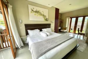 a bedroom with a large bed with white sheets and pillows at Double U Camp and Villa in Kubupenlokan