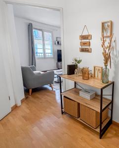 a living room with a table and a chair at Studio cosy avec Smart TV & Wi-Fi in Le Plessis-Robinson +25 photos