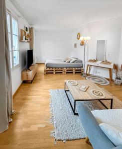 a living room with a bed and a table at Studio cosy avec Smart TV & Wi-Fi in Le Plessis-Robinson