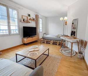 a living room with a tv and a couch at Studio cosy avec Smart TV & Wi-Fi in Le Plessis-Robinson