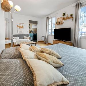 a living room with two beds with pillows on them at Studio cosy avec Smart TV & Wi-Fi in Le Plessis-Robinson