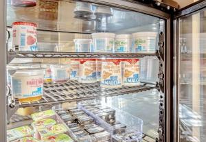 a refrigerator filled with milk and other food items at B&B HOTEL Brignoles in Brignoles