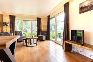 a living room with a flat screen tv and a living room with a couch at Recreatiepark de Wielerbaan in Wageningen