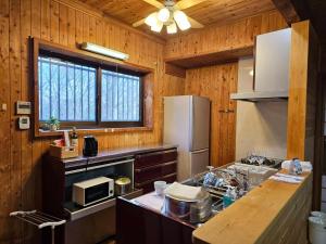 a kitchen with a refrigerator and a counter top at Pet friendly NASU Royal Villa ペットと泊まれる広々貸切別荘 那須ロイヤルヴィラBBQ駐車5台OK in Nasu