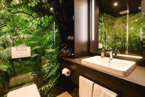 美因河畔法兰克福Rioca Frankfurt Posto 7的一间带水槽和大型绿色植物的浴室 更多37张照片