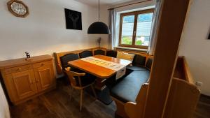 a dining room with a table and chairs and a clock at Ferienwohnung Pauliner in Oberstdorf
