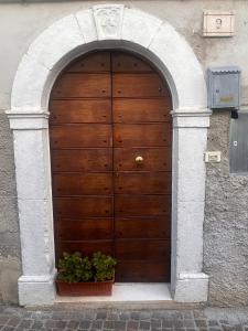 drewniane drzwi w budynku z dwoma doniczkami w obiekcie La casetta del Pastore w mieście Sulmona