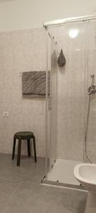 a bathroom with a shower and a stool and a sink at Olive Tree House in Riva del Garda