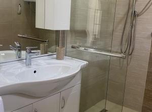 a bathroom with a sink and a glass shower at Luxury Lovran Apartments with Swimming Pool in Lovran