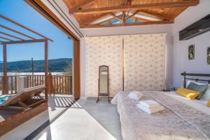 a bedroom with a bed and a balcony at Sea Rock Apartment in Ayia Evfimia