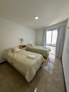 a bedroom with two beds and a window at Duplex para 5 personas t4 in Guaymallen +8 photos