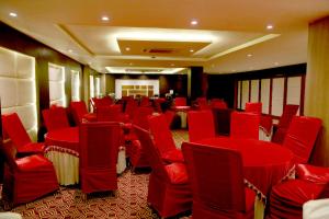 a conference room with red chairs and tables in it at Le Roi Udaipur in Udaipur +111 photos