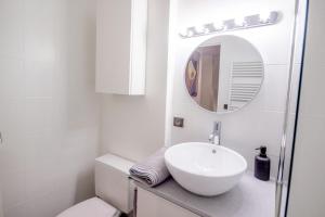 une salle de bain blanche avec un lavabo et un miroir dans l'établissement Appartement idéal en plein centre ville proche lac, à Annecy