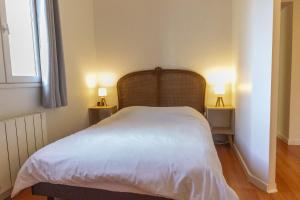 une chambre avec un lit blanc avec deux tables de nuit dans l'établissement Appartement idéal en plein centre ville proche lac, à Annecy
