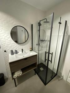 a bathroom with a sink and a shower with a mirror at Smart Residencial in Villanueva de la Cañada