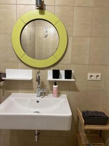 a bathroom with a sink and a yellow mirror at Turmfalke in Germaringen +17 photos
