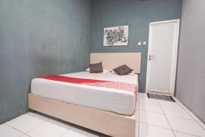 a bedroom with a large white bed in a room at OYO 94394 Hawai Inn in Makassar