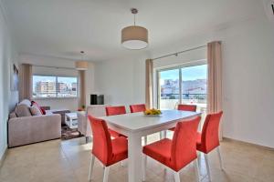 sala de estar con mesa blanca y sillas rojas en Lagos Palm Tree 1 with Pool by Homing, en Lagos