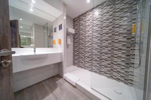 a bathroom with a sink and a glass shower at Premier Inn Dubai Barsha Heights in Dubai