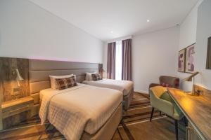 ドバイにあるPremier Inn Dubai Barsha Heightsのベッド2台と机があるホテルの部屋 +36枚の写真