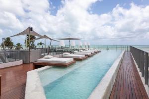a pool with lounge chairs and umbrellas on a resort at Yacht by Hosppedar in João Pessoa