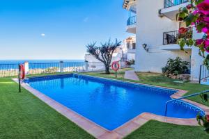 a swimming pool next to a building and the ocean at Mijas Pueblo, 3 terraces & pool with sea view in Mijas
