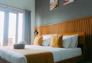 Un dormitorio con una cama grande con almohadas amarillas. en Escape Bajo, en Labuan Bajo