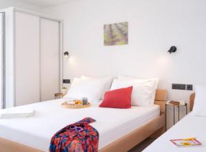 ein weißes Bett mit einem Teller Essen drauf in der Unterkunft Vacation House Jadranko in Gdinj