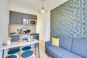 a living room with a blue couch and a kitchen at Bluestay 141 - Superb apartment in Bagnolet