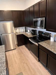 a kitchen with black cabinets and a stainless steel refrigerator at Stylish Home Perfect for Your Stay in Leander +3 photos