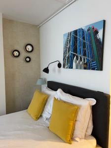 a bedroom with a bed with yellow and white pillows at Appartement Seine et Marais in Paris