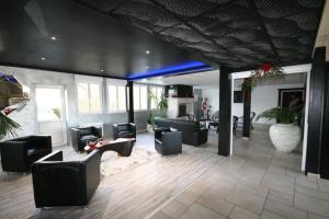 eine Lobby mit Sofas und Stühlen in einem Zimmer in der Unterkunft Hotel Air-lane in Saint-Léger-sous-Brienne