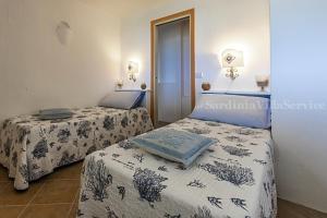 due letti in una stanza con due letti sidx sidx sidx di Villetta Belvedere 2 - Porto Cervo a Arzachena