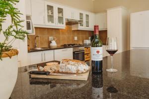 a bottle of wine sitting next to a glass of wine at Manor One Kingswood Golf Estate in George