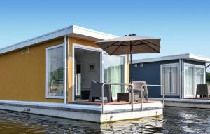 马斯特里赫特House Boat Antigua的水边的房子,配有遮阳伞和椅子