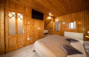 a bedroom with a bed in a wooden room at Poiana Cristian in Poiana Brasov