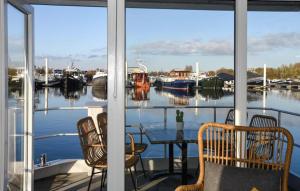 a porch with a table and chairs and boats in the water at House Boat Vrijthof in Maastricht