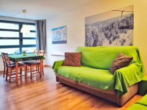 ein grünes Sofa im Wohnzimmer mit einem Tisch in der Unterkunft A pie de pistas de La Molina, la mejor ubicación in La Molina