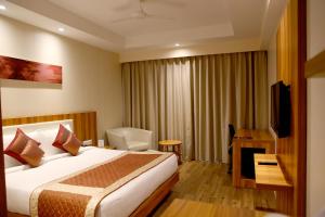 een hotelkamer met een bed en een televisie bij Le Roi Udaipur in Udaipur