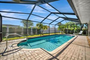 an indoor swimming pool with a glass roof at The Crown House 4b Pool Home 6 mins to IR Beach in Largo