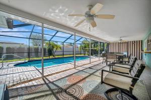 a patio with a pool and a ceiling fan at The Crown House 4b Pool Home 6 mins to IR Beach in Largo +24 photos