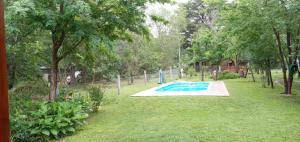 una piscina in un cortile con alberi e erba di La Soñada a Villa Quillinzo