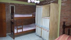 2 letti a castello in una camera con muro di mattoni di La Soñada a Villa Quillinzo Altre 11 foto